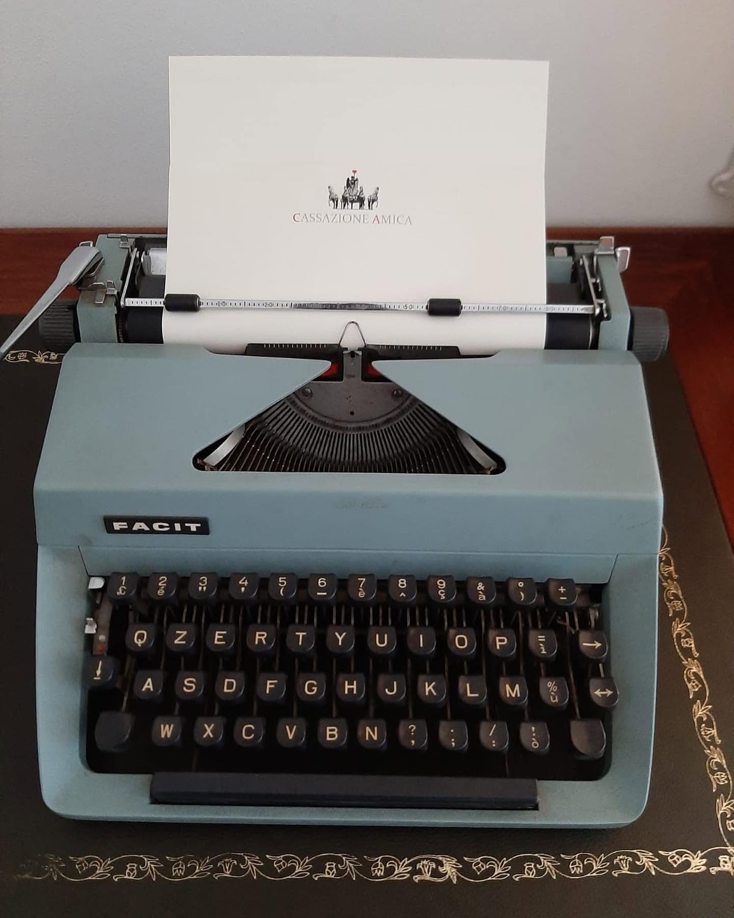 Macchina da scrivere d'epoca con carta intestata Cassazione Amica, su scrivania in pelle